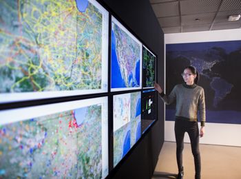 A student points to a location on a map of the U.S.