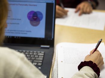 A student writes on a notebook