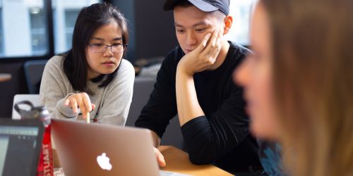 Photo of Stuart School of Business students at work around a laptop