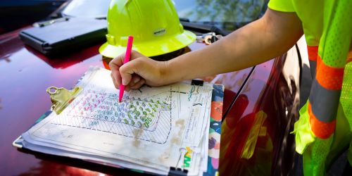 An Illinois Tech student works on plans in the field