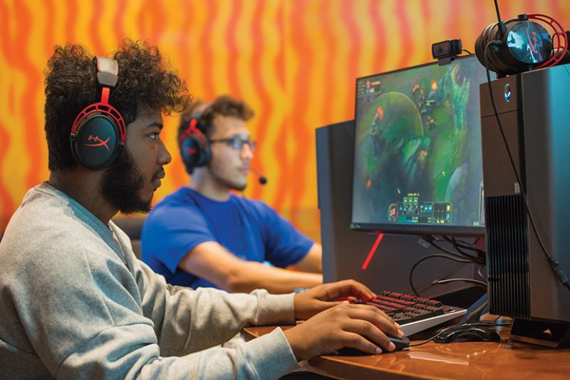 Undergraduate students in the Esports room working on computers
